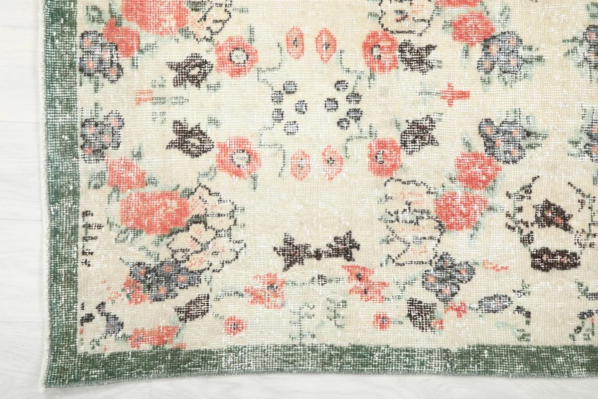Corner detail showing the green border and the transition to the floral field.