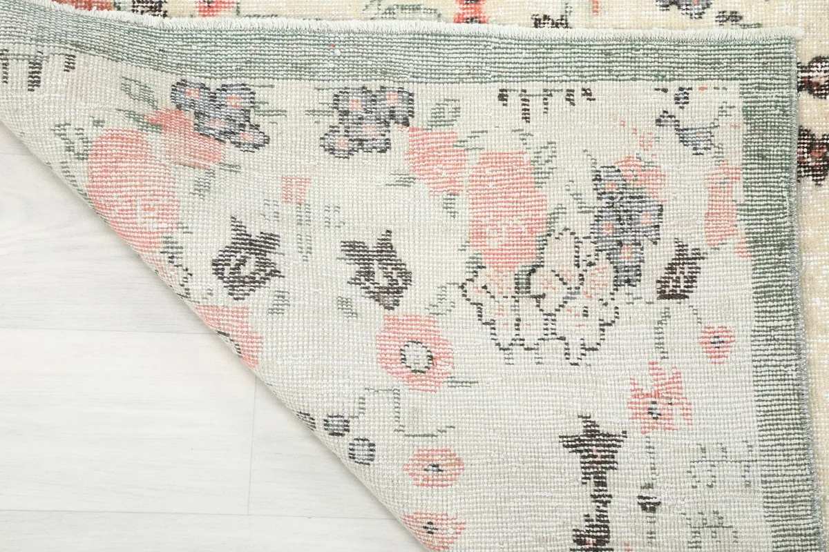 Folded corner of the rug, showing the reverse side of the hand-knotted wool and cotton.