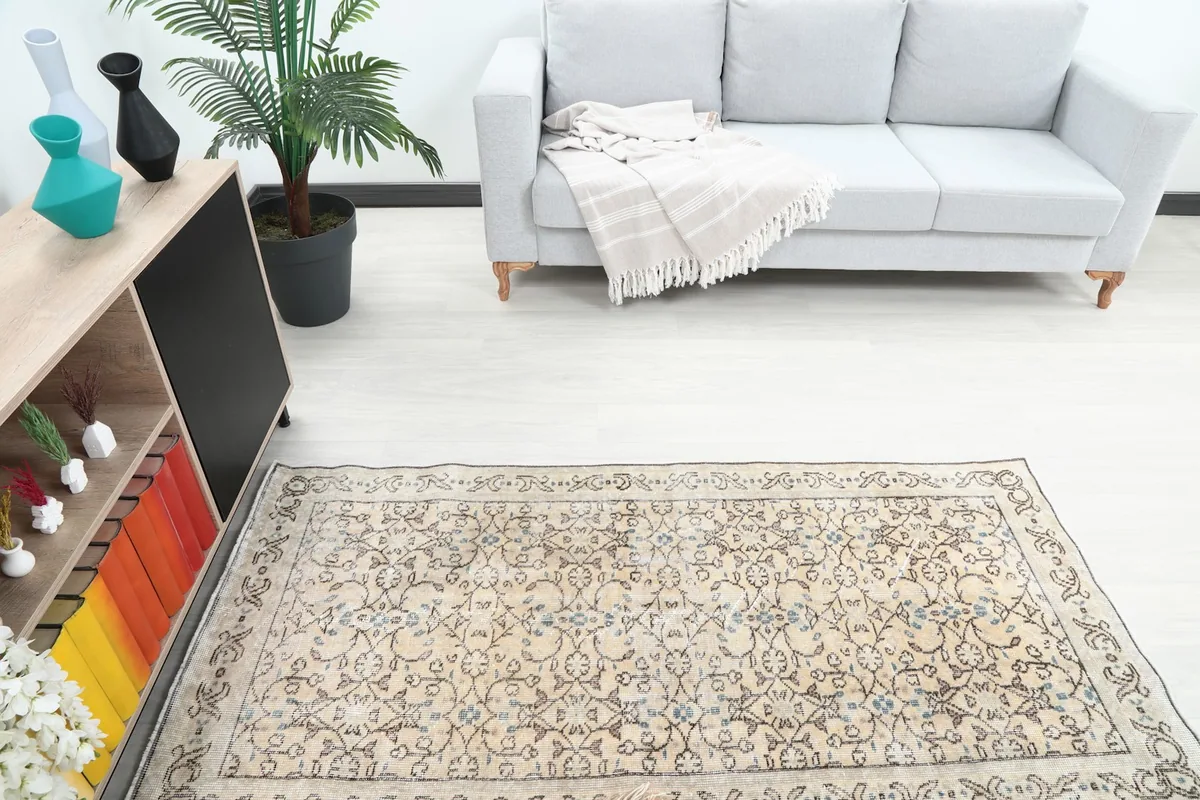 Overhead view of the beige and brown rug in a room, showing its placement relative to furniture
