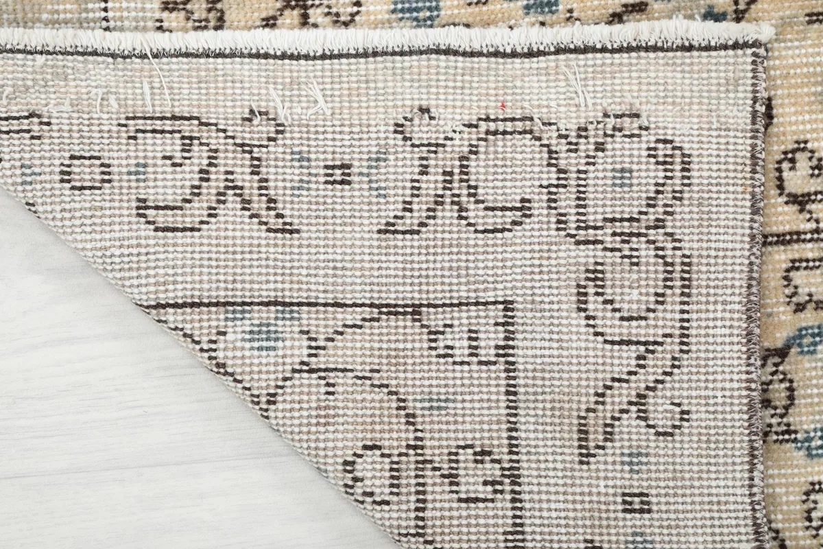 Underside of the rug's corner, revealing the tightly woven cotton foundation