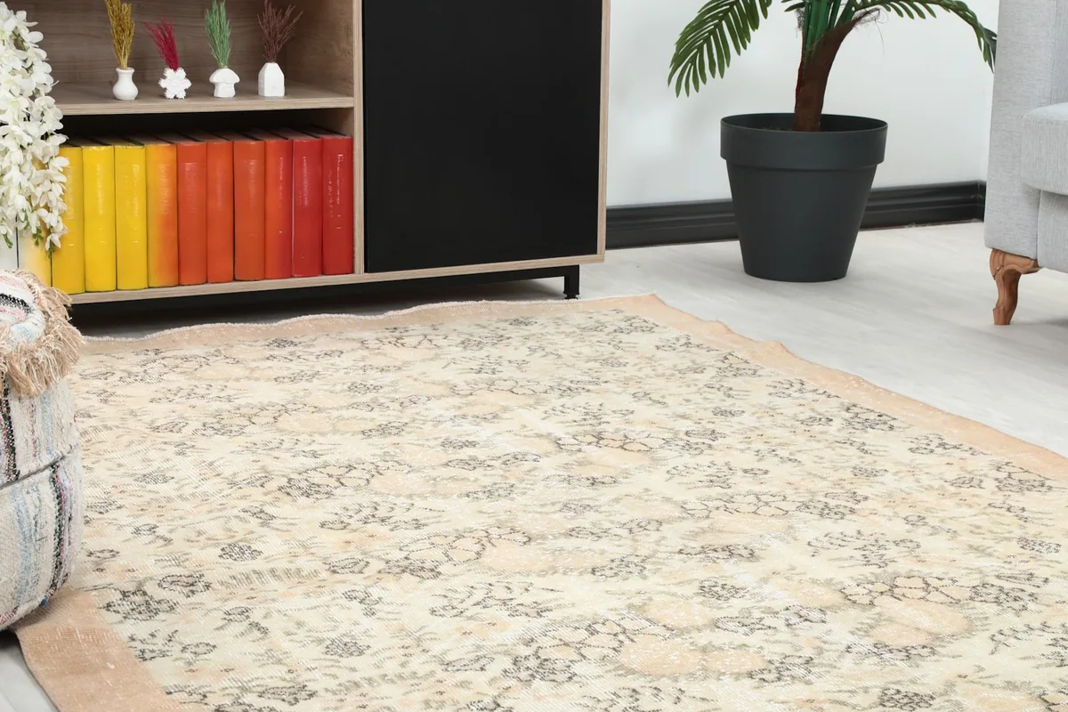 Close-up angle shot of the cream rug with floral patterns near a wooden cabinet