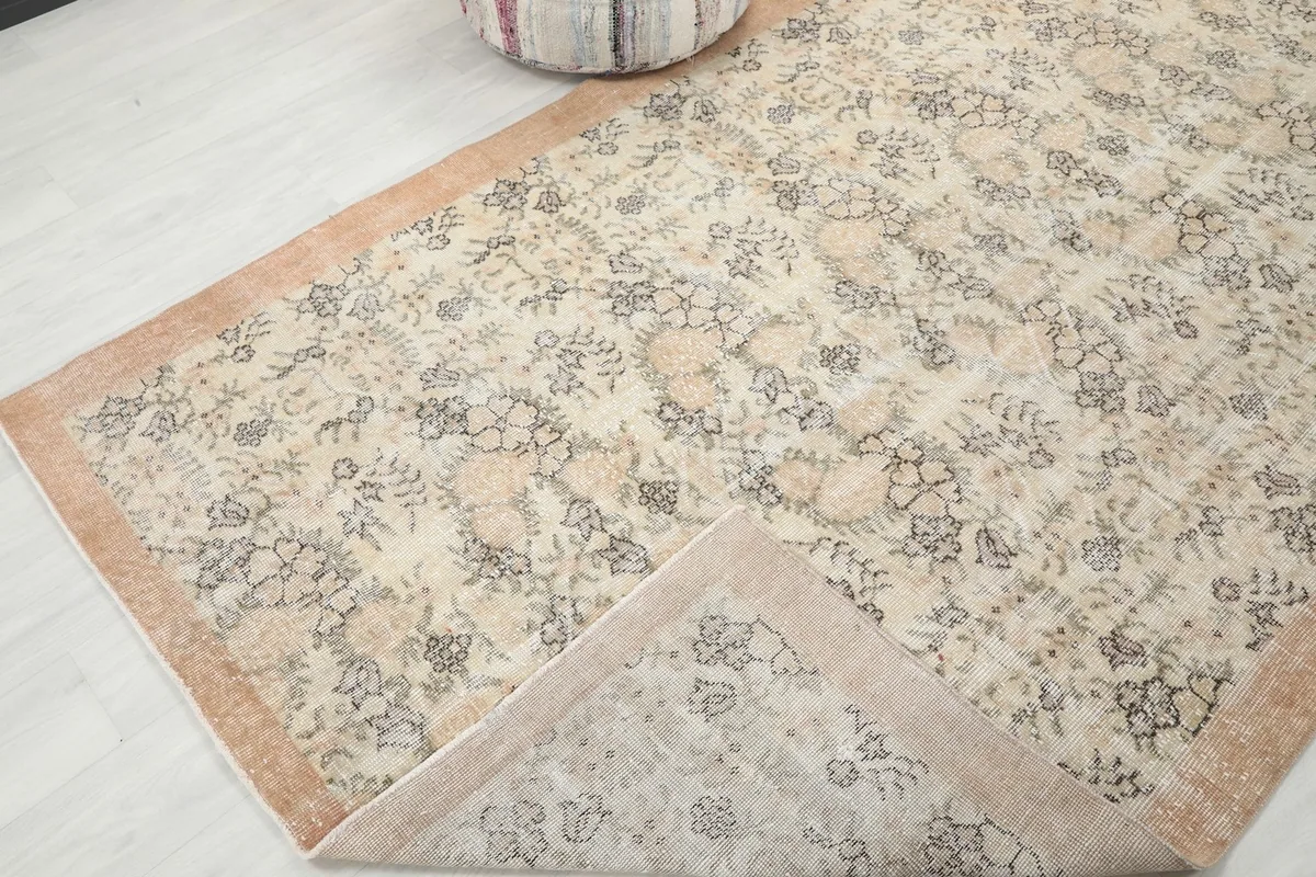 Corner of the rug folded back, revealing the hand-knotted construction
