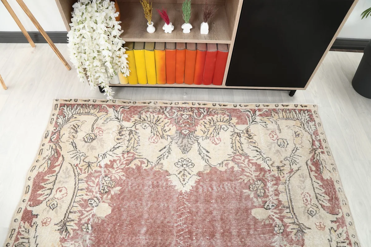 Detail of the upper section of the rug, highlighting the floral motifs in the border against the rose field.