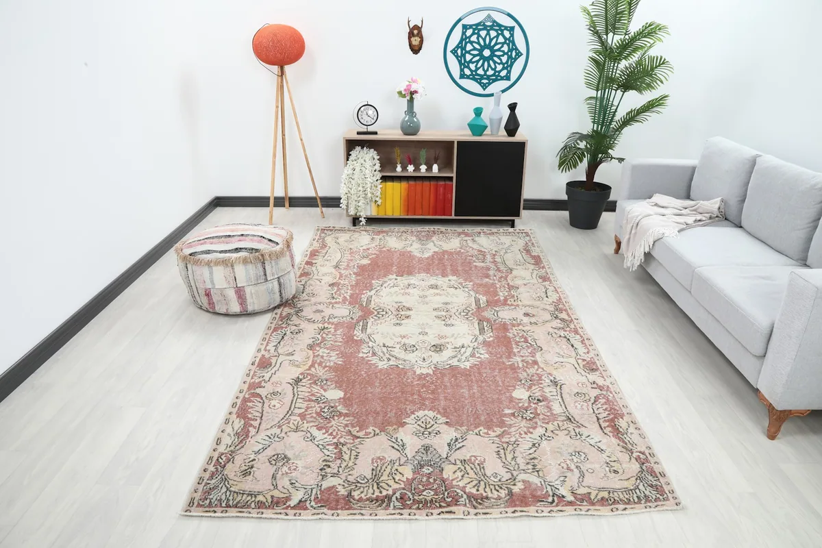Vintage Anatolian rug displayed in a modern living room setting with a gray sofa and wooden furniture.