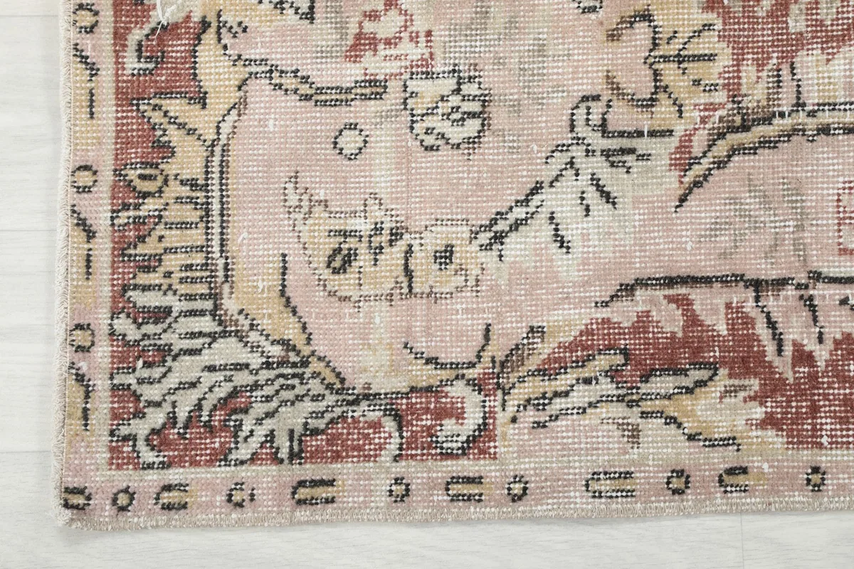 Close-up of the rug's outer border, displaying intricate patterns and the varied color palette.