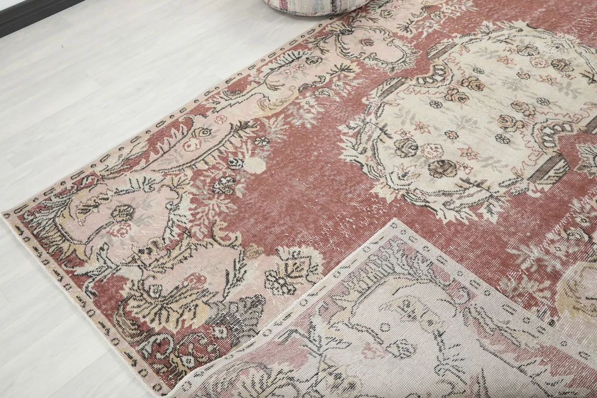 Corner of the vintage rug folded back to reveal the back of the hand-knotted cotton foundation.