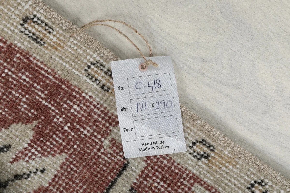 Product tag on the rug showing its dimensions in centimeters and confirming it is hand-made in Turkey.