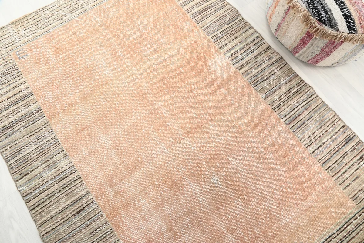 Close overhead view of the rust and beige striped rug, showcasing the color variation and texture.