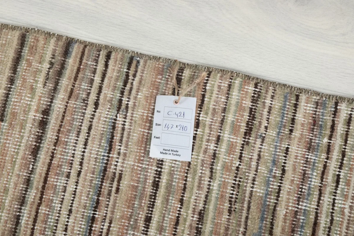 Close-up of the rug's edge with a product tag showing its dimensions and origin.