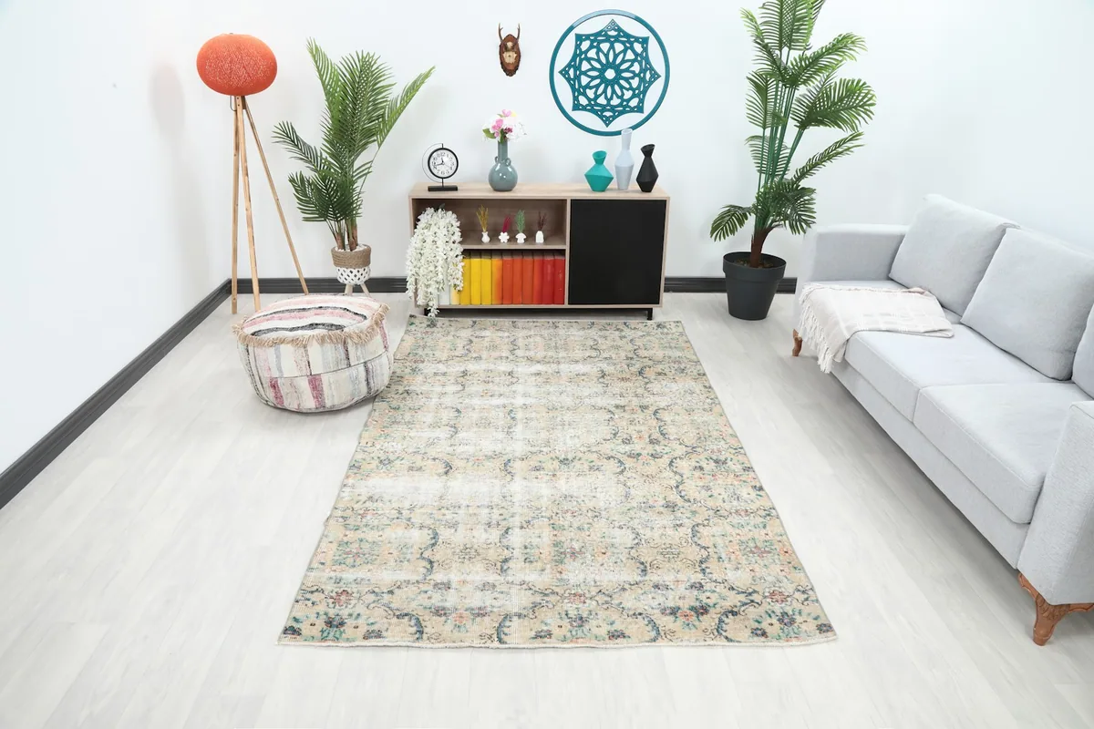 Vintage Anatolian rug with beige floral pattern placed in a modern living room setting