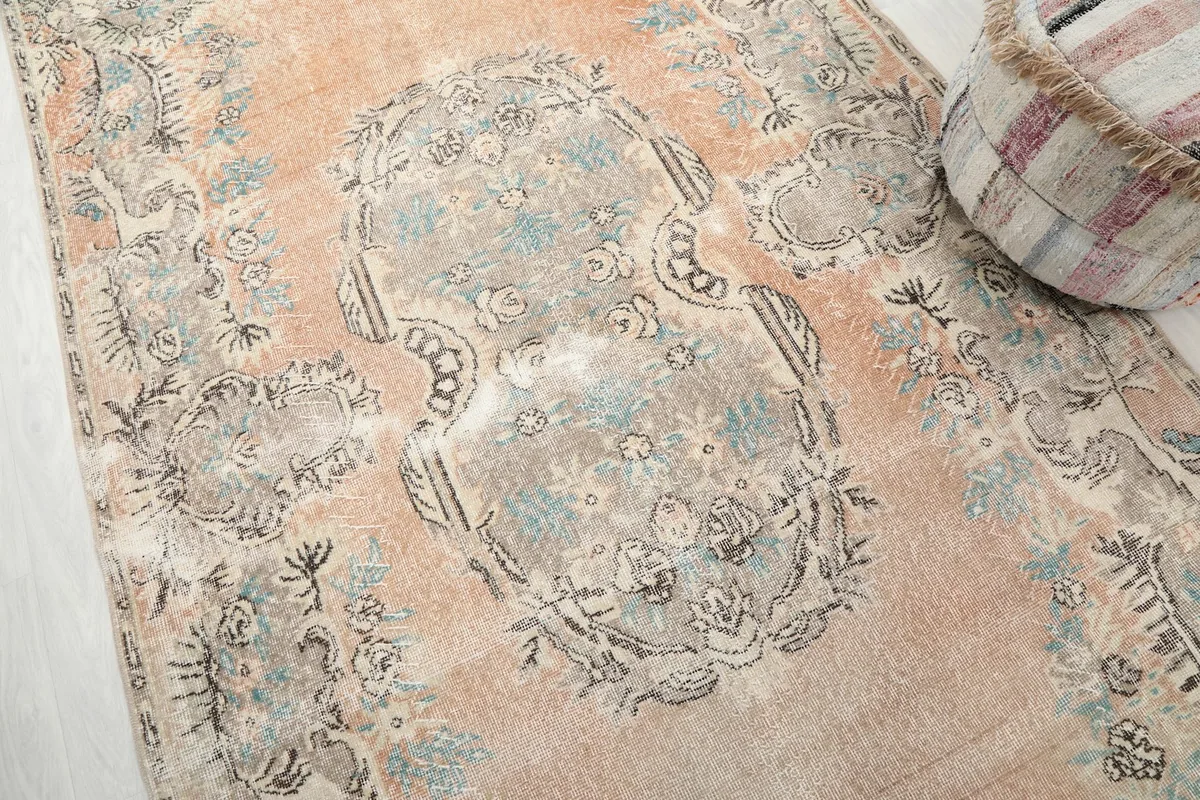 Close-up view of the central medallion and surrounding floral elements in gray and blue