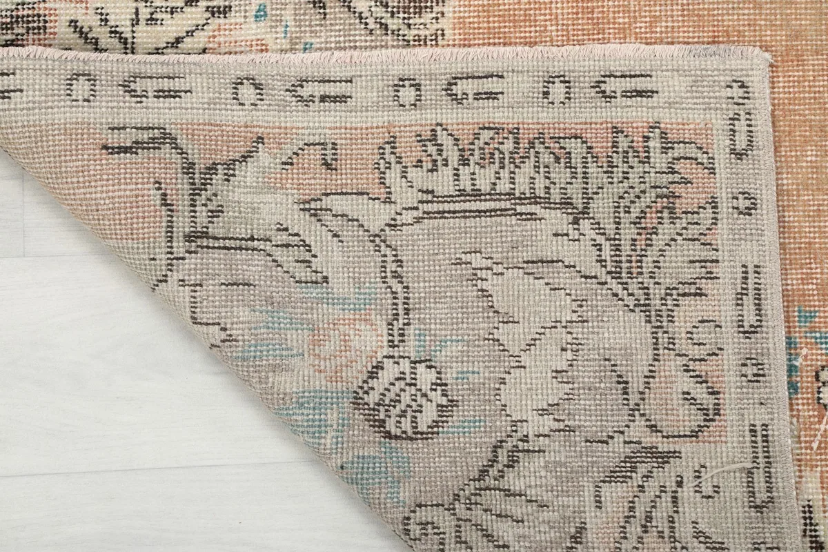 Underside of the rug, showing the cotton foundation and the reverse of the hand-knotted wool pile