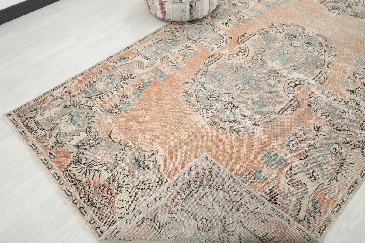 Corner of the rug folded back, revealing the underside and showing the hand-knotted construction