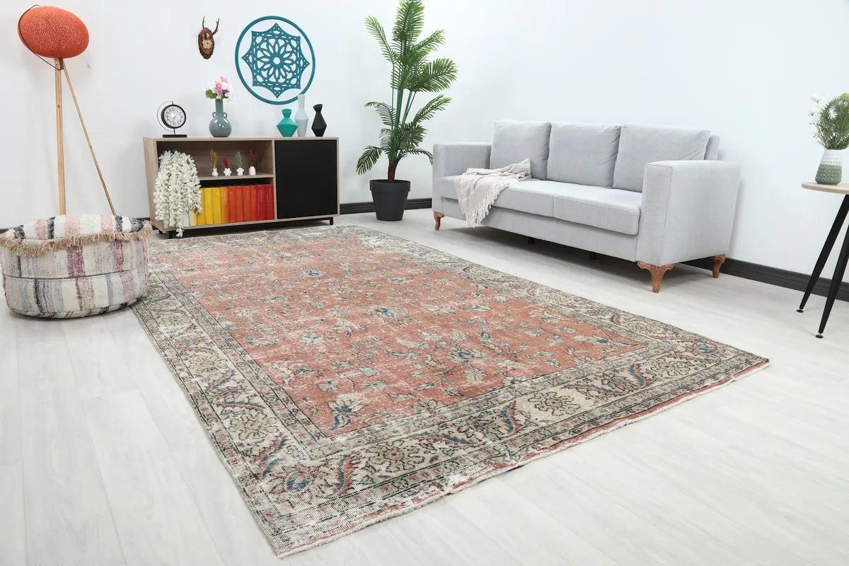 Angle view of the rust and beige floral rug showcasing its size within a living space with contemporary furniture.