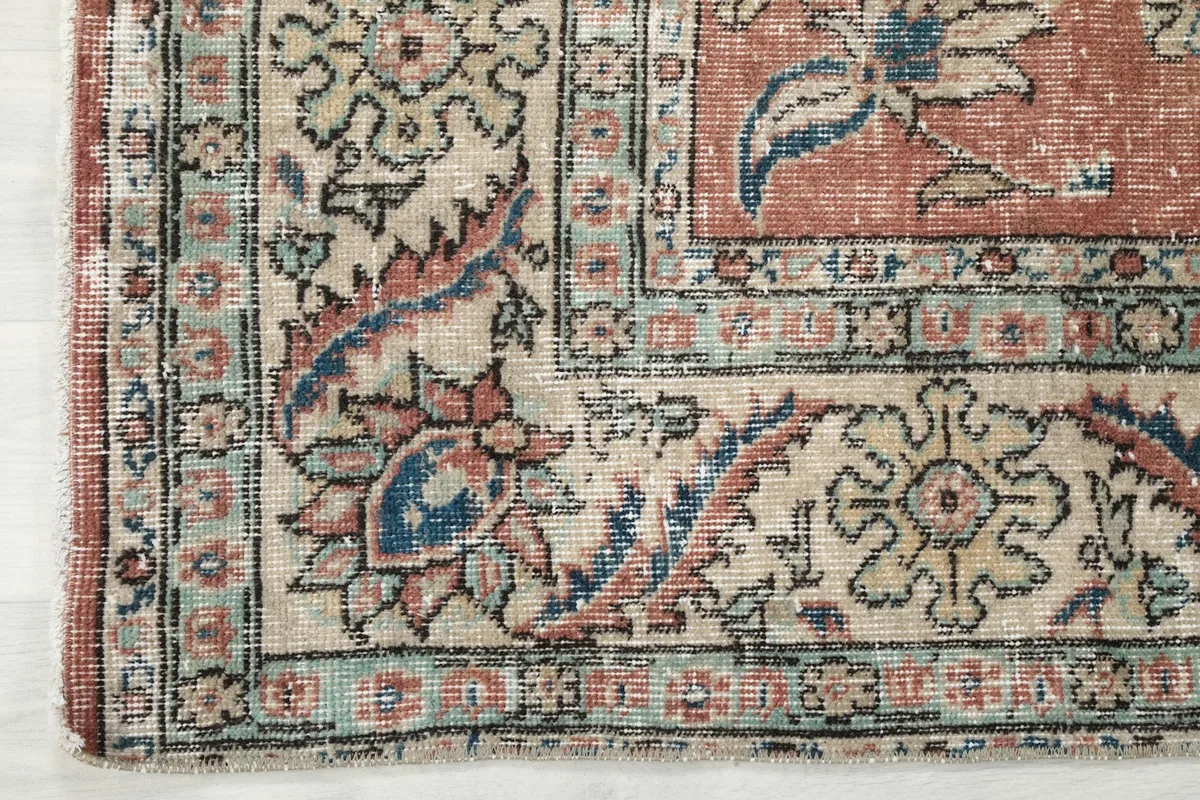 Close-up of a corner, highlighting the detailed beige border with its complementary floral and geometric patterns.
