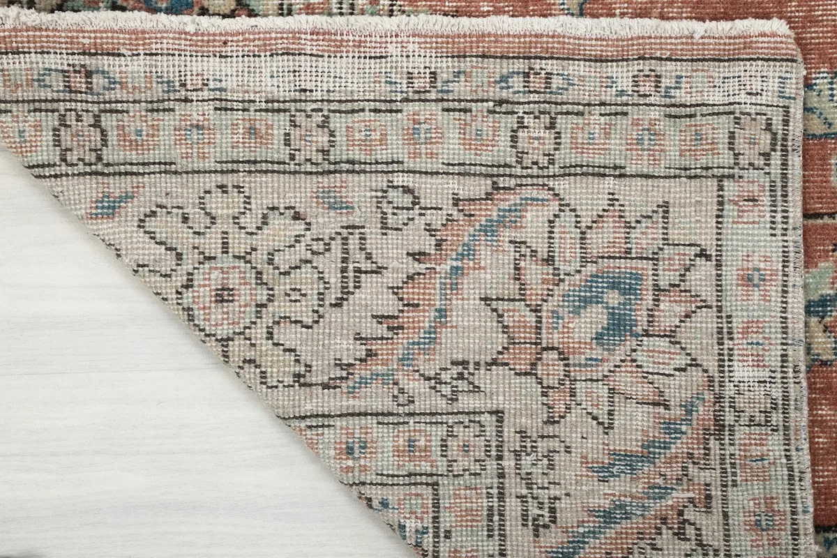 Close-up of the rug's underside, showing the reverse of the hand-knotted construction and the cotton foundation.