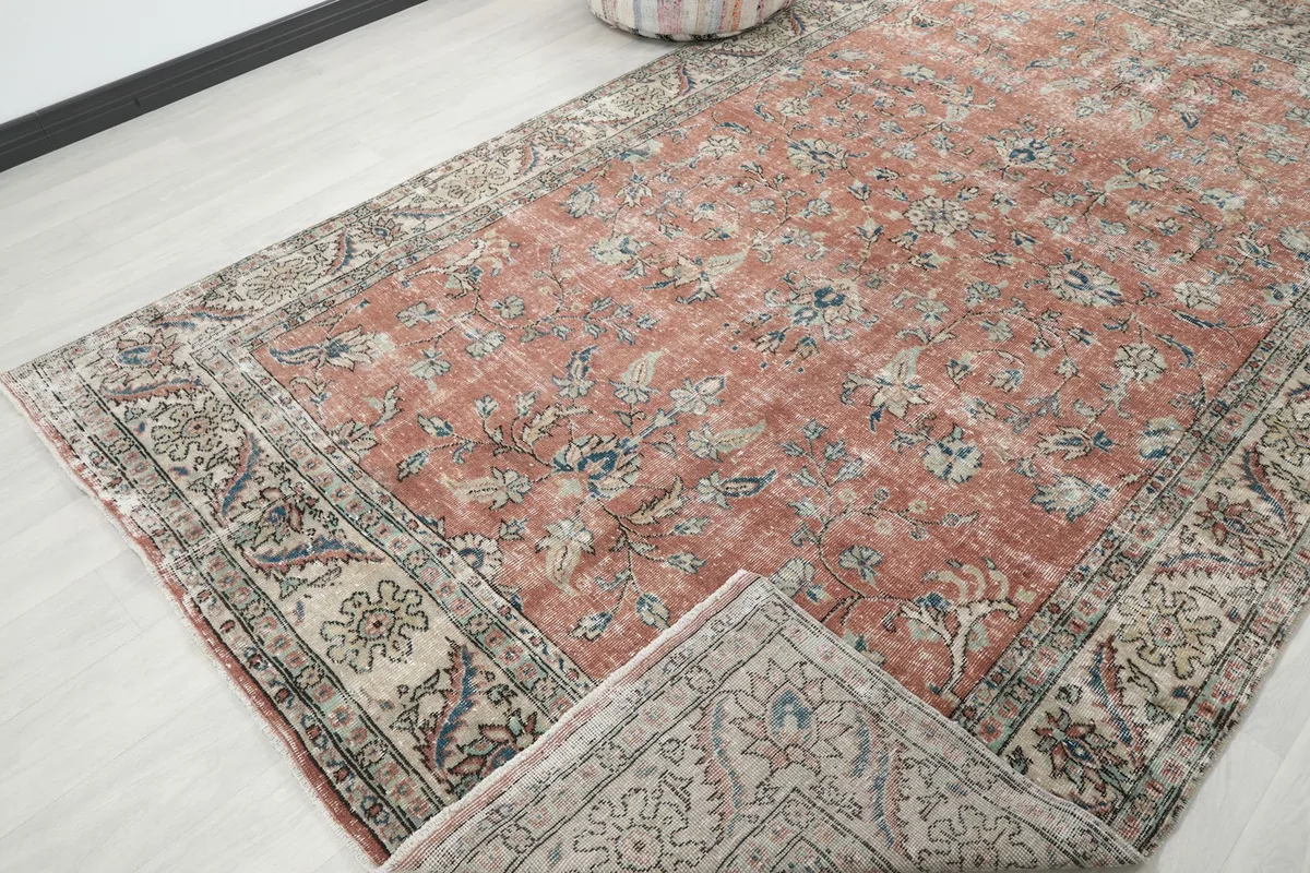 View of the rug partially folded, revealing the reverse side of the hand-knotted cotton foundation.