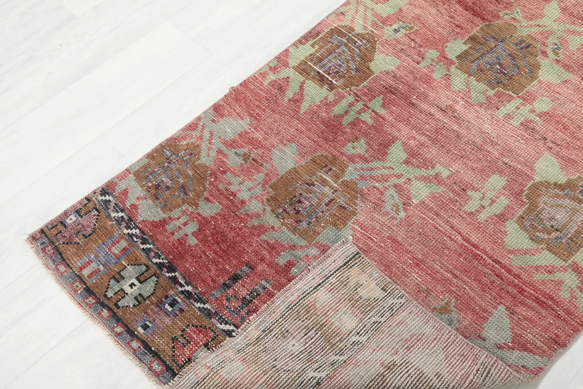 Faded Rose Floral Anatolian Runner folded back to show the cotton foundation and reverse side.