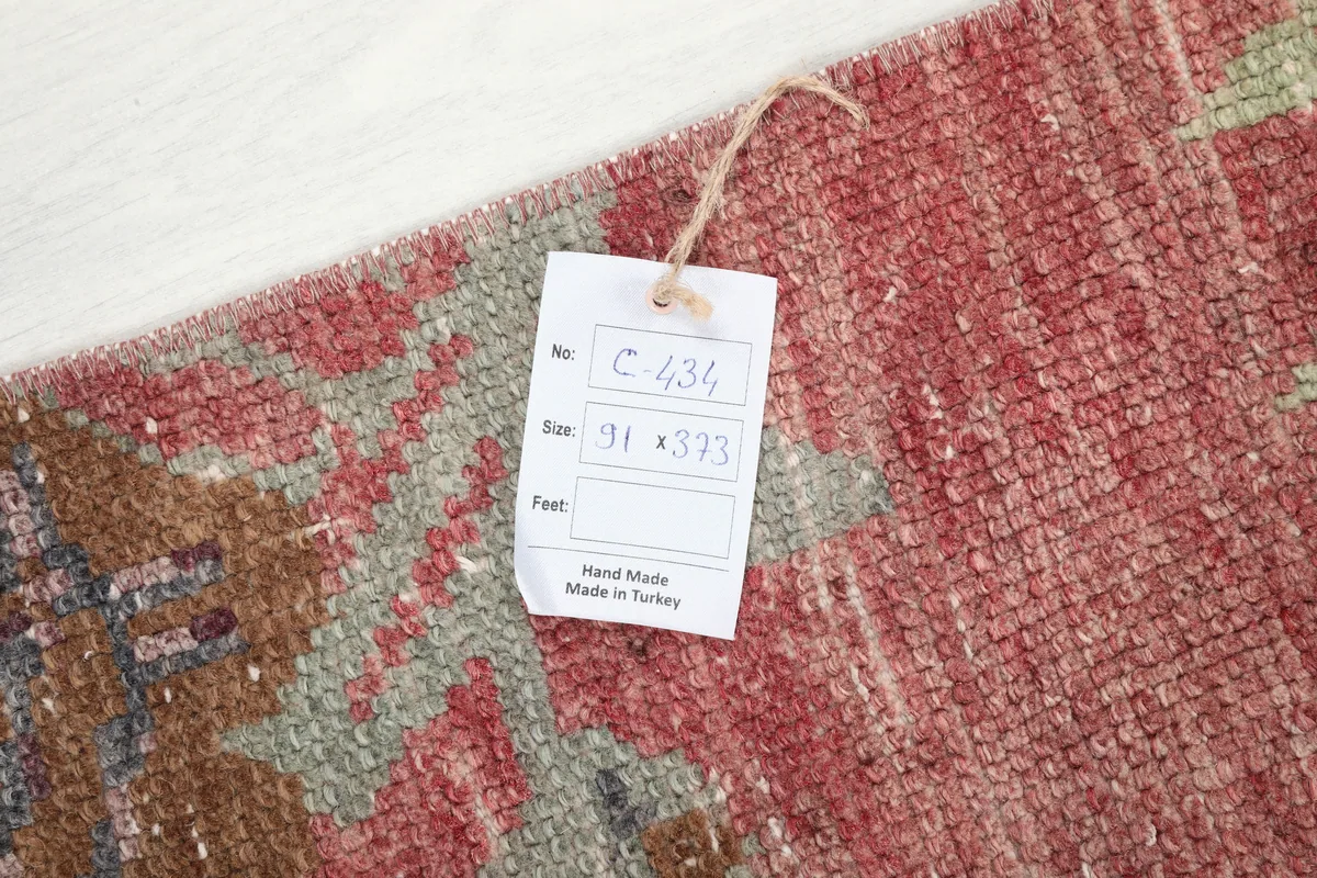 Close-up of the Faded Rose Floral Anatolian Runner with a size tag, showing the rug's texture and colors.