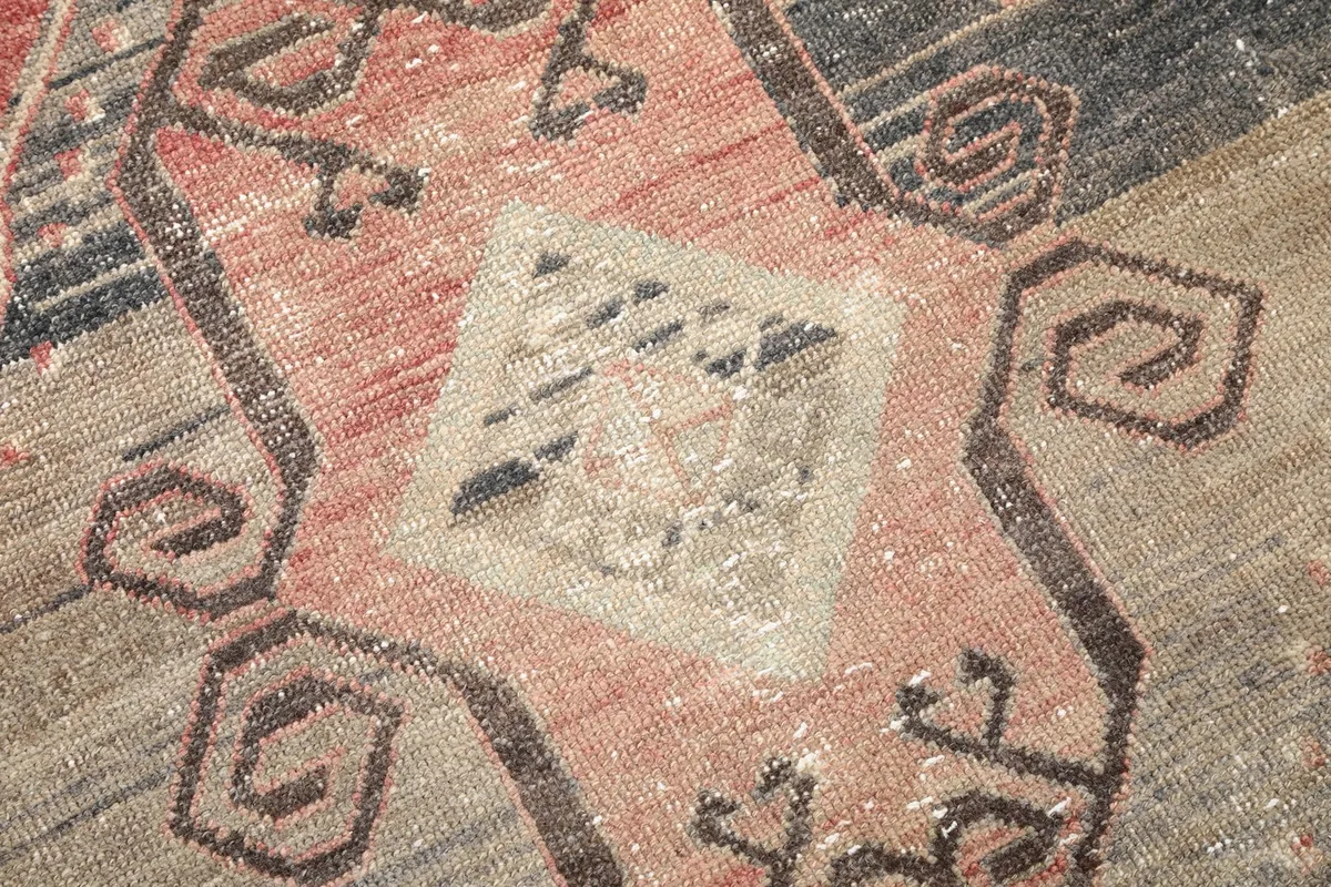 Macro detail of the hand-knotted wool pile and the intricate tribal pattern elements