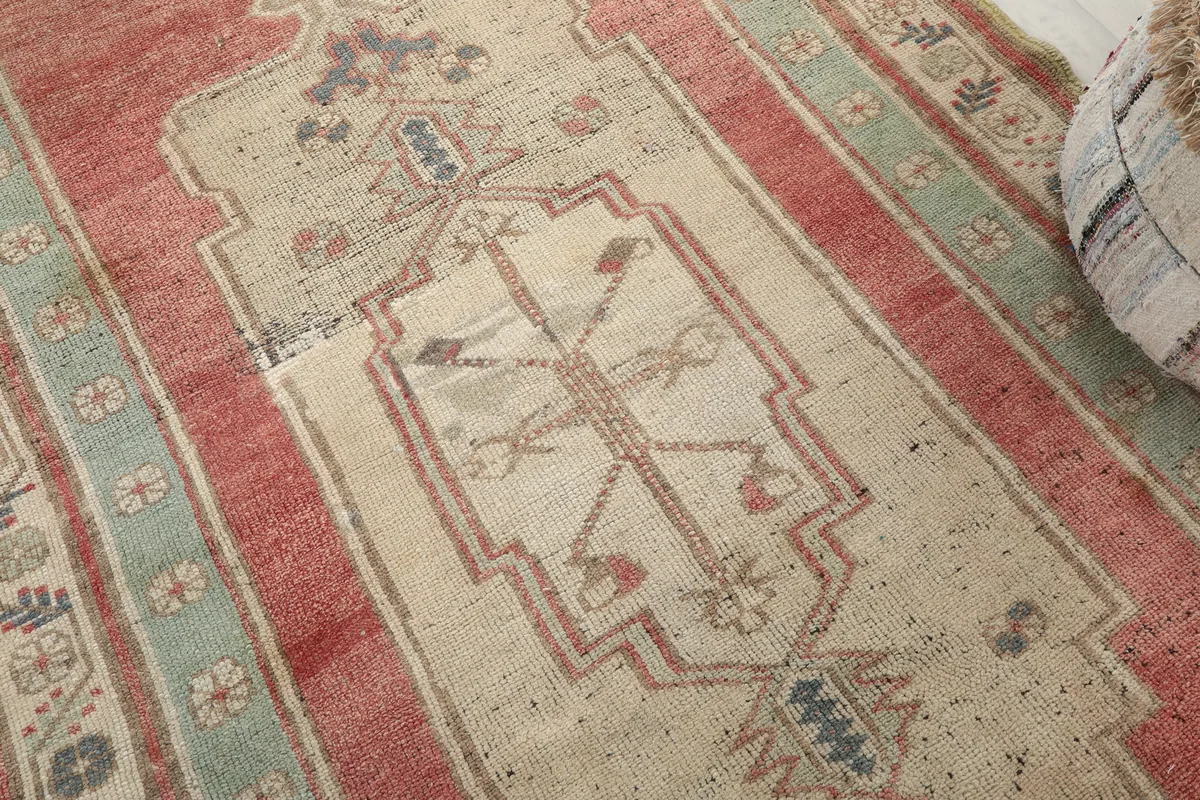 Detailed shot of the ivory medallion on the Rust Medallion Anatolian Area Rug, showing geometric motifs.