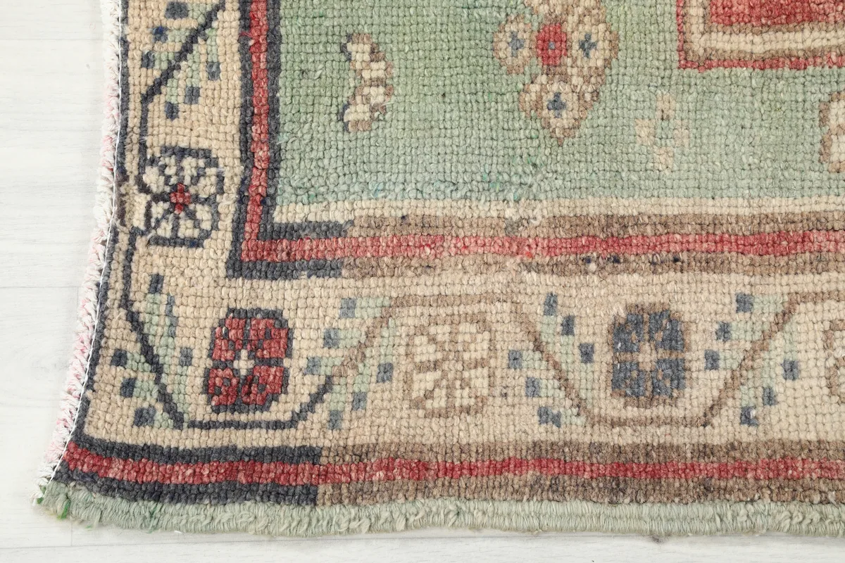 Detail of the green border and corner design of the Rust Medallion Anatolian Area Rug.