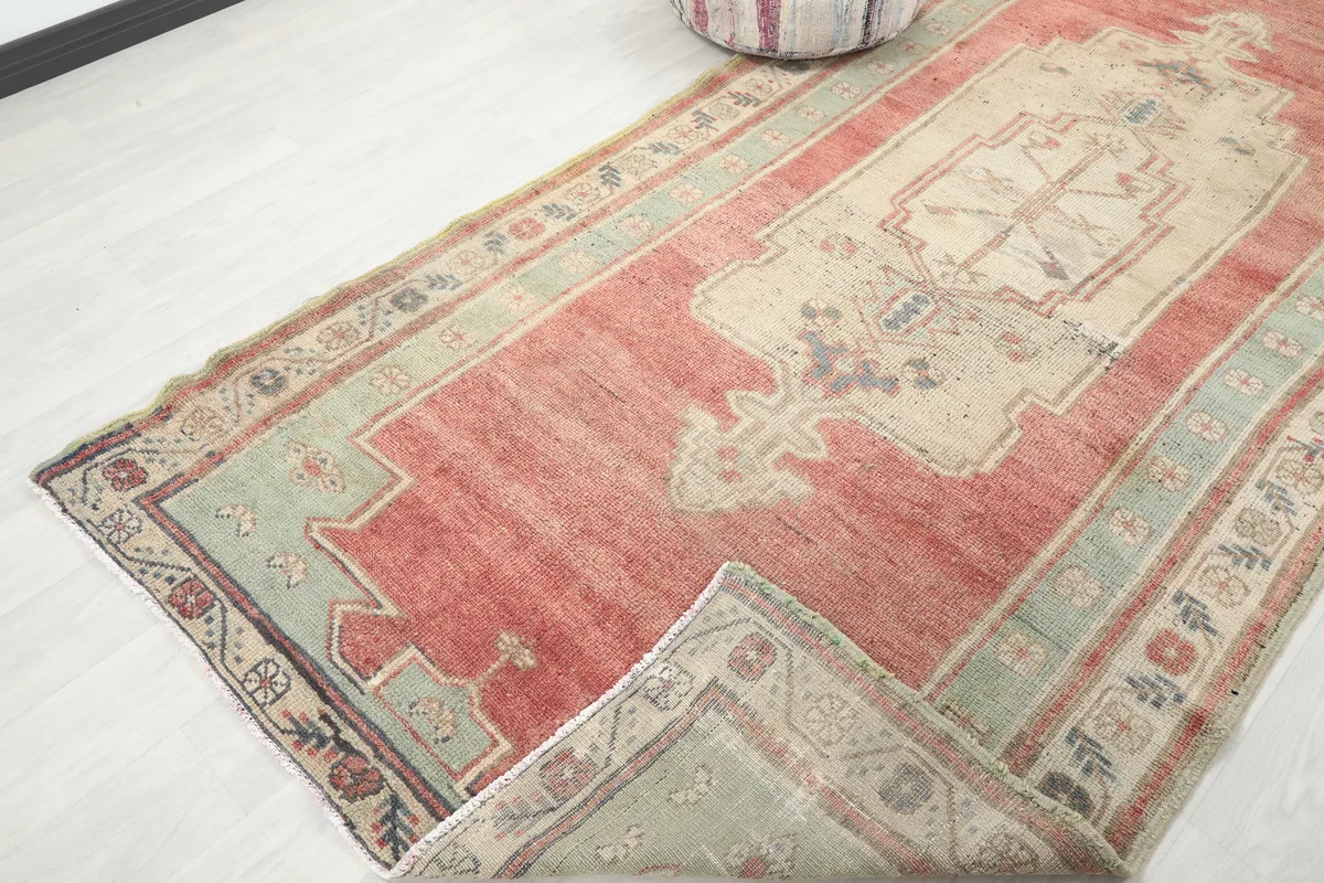 Corner of the Rust Medallion Anatolian Area Rug folded back, showing the back of the rug.