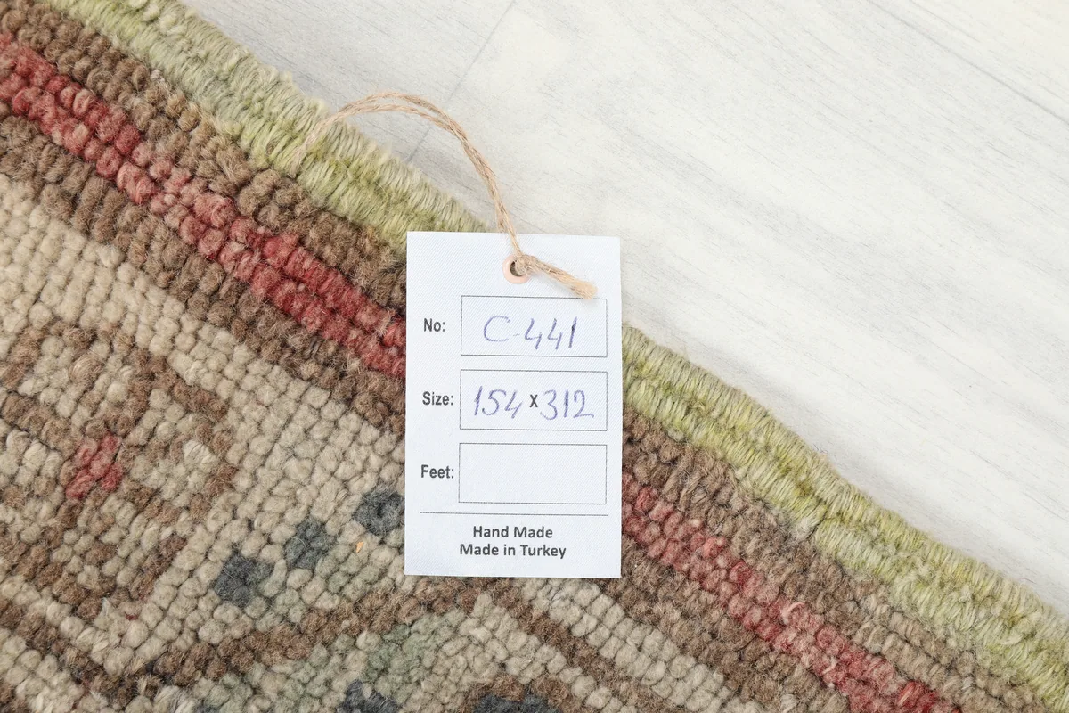 Care tag attached to the Rust Medallion Anatolian Area Rug, showing size and origin details.