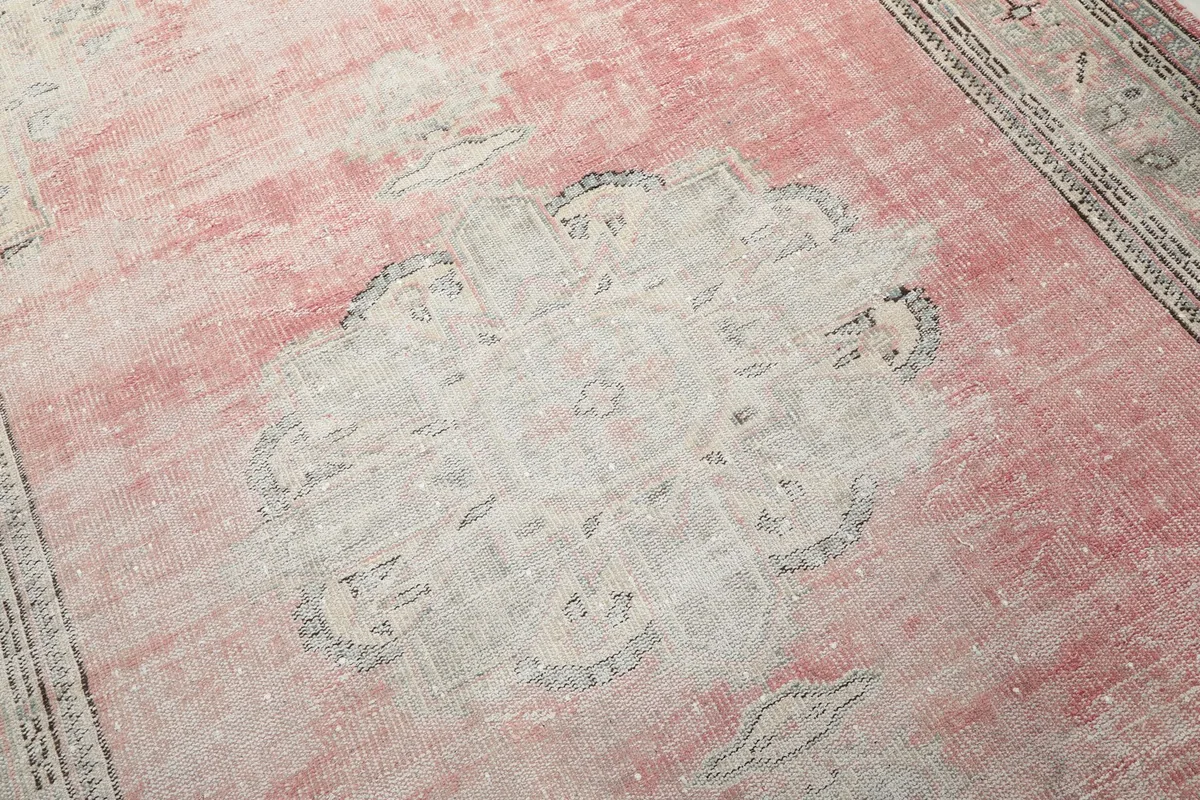 Detailed view of the central medallion and surrounding rose field, highlighting the rug's patina.