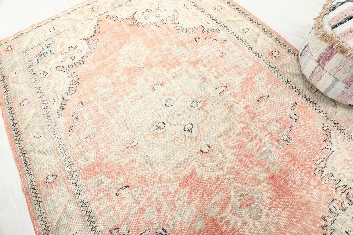 Close-up detail of the central medallion and surrounding geometric motifs on the vintage wool rug