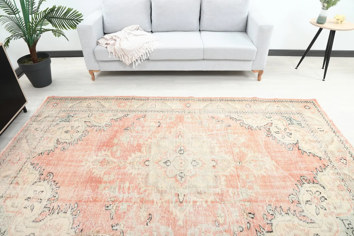Overhead view of the vintage rug's central design and colors, placed in a room with a sofa