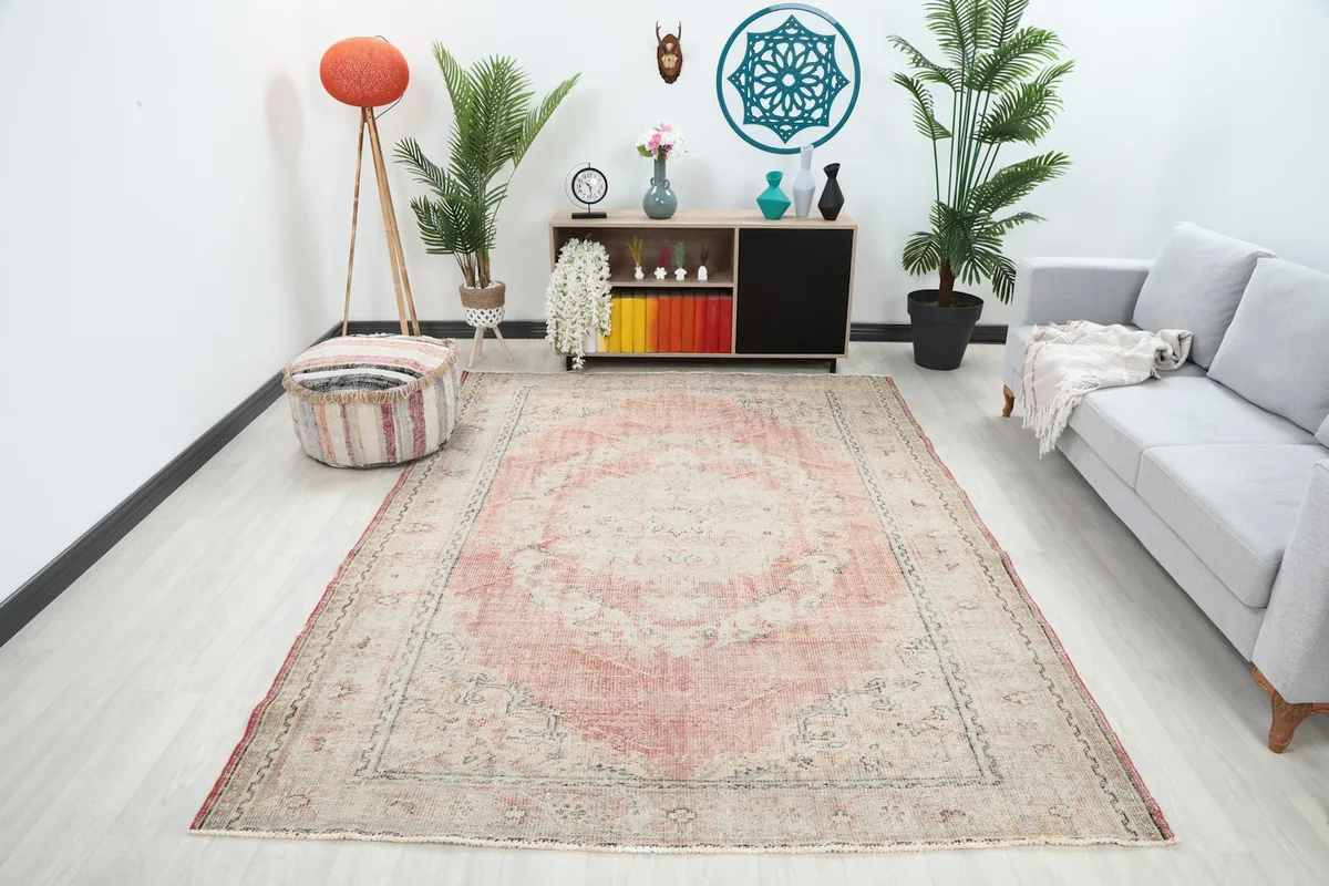 Vintage rose and beige rug in a contemporary living room setting with a gray sofa