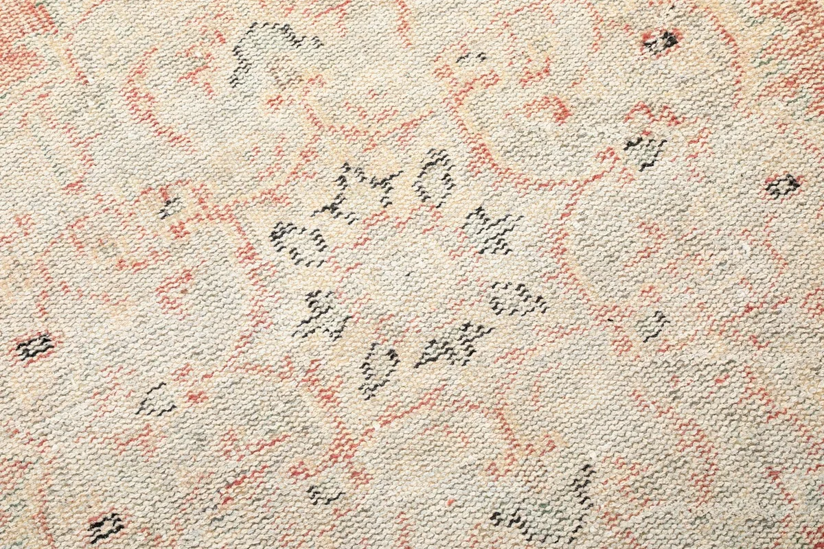 Detailed view of the wool pile and geometric motifs with gray accents on the rug surface