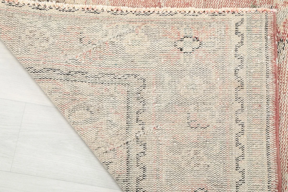 View of the back of the vintage rug, revealing the hand-knotted cotton foundation