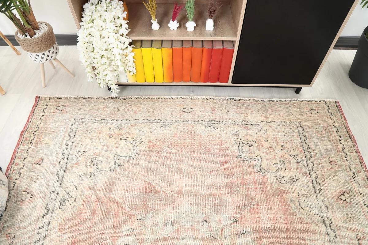 Overhead shot highlighting the central medallion and faded rose tones of the rug