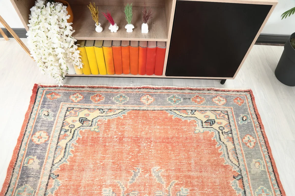 View of one end of the rug, highlighting the border and field design near furniture.