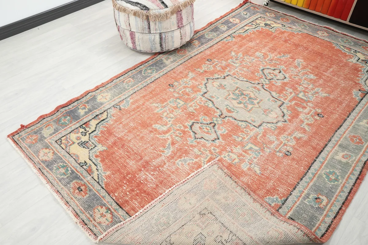 Angled view of the rug with a corner folded back, revealing the underside and pile.