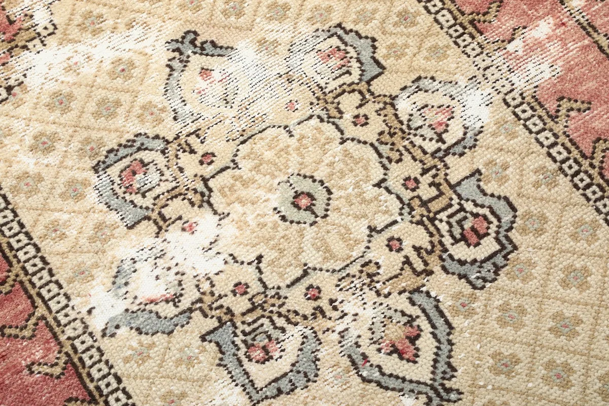 Close-up of the intricate floral and geometric patterns within the rug's medallion