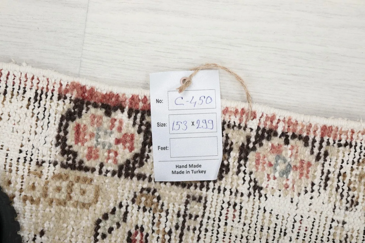 Tag showing the rug's dimensions in centimeters (153x299) and its origin as handmade in Turkey