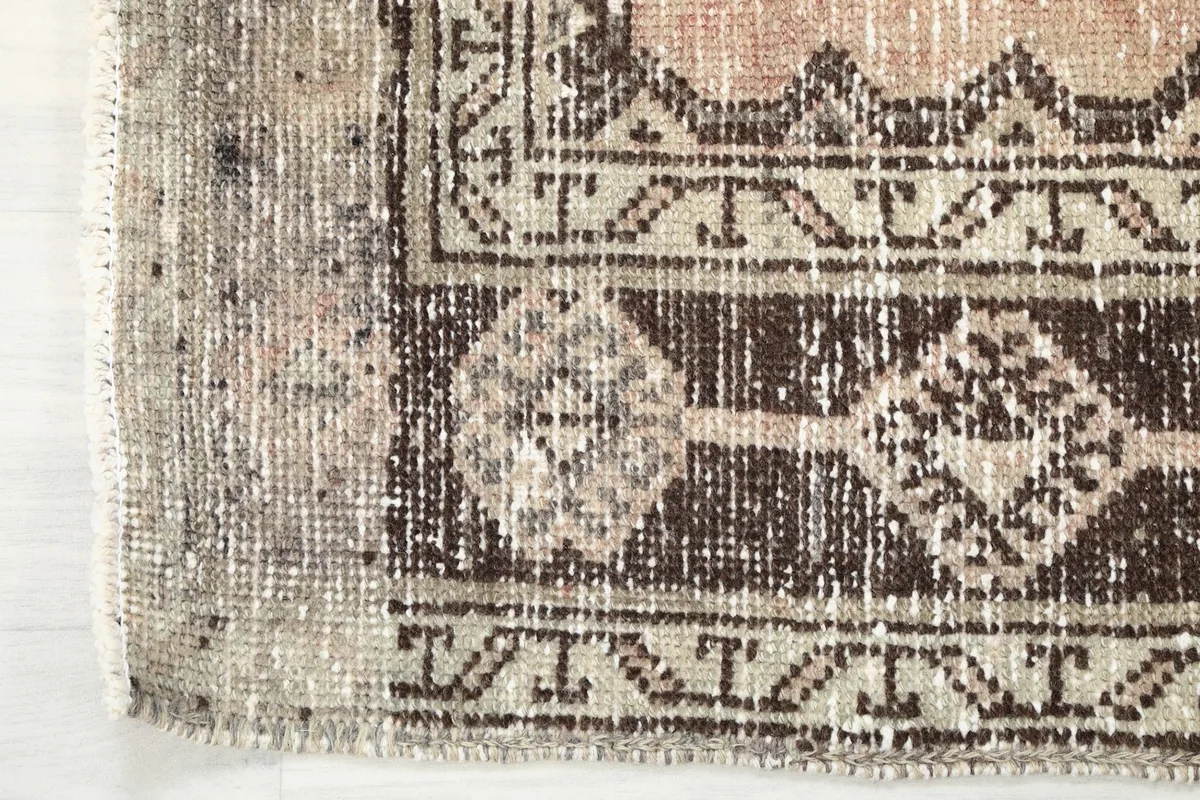 Close-up of the rug's edge, showing the intricate border design and the short, even fringe