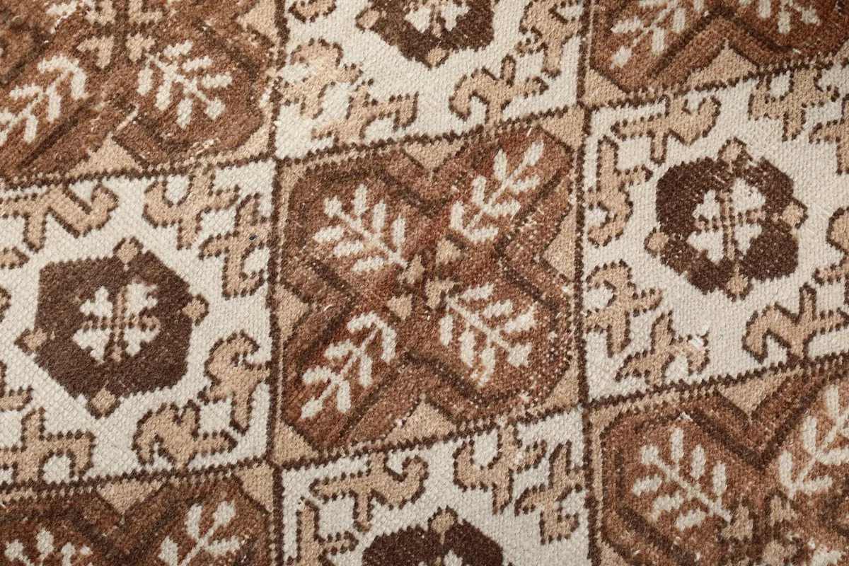 Close-up detail of the hand-knotted wool pile and intricate geometric motifs