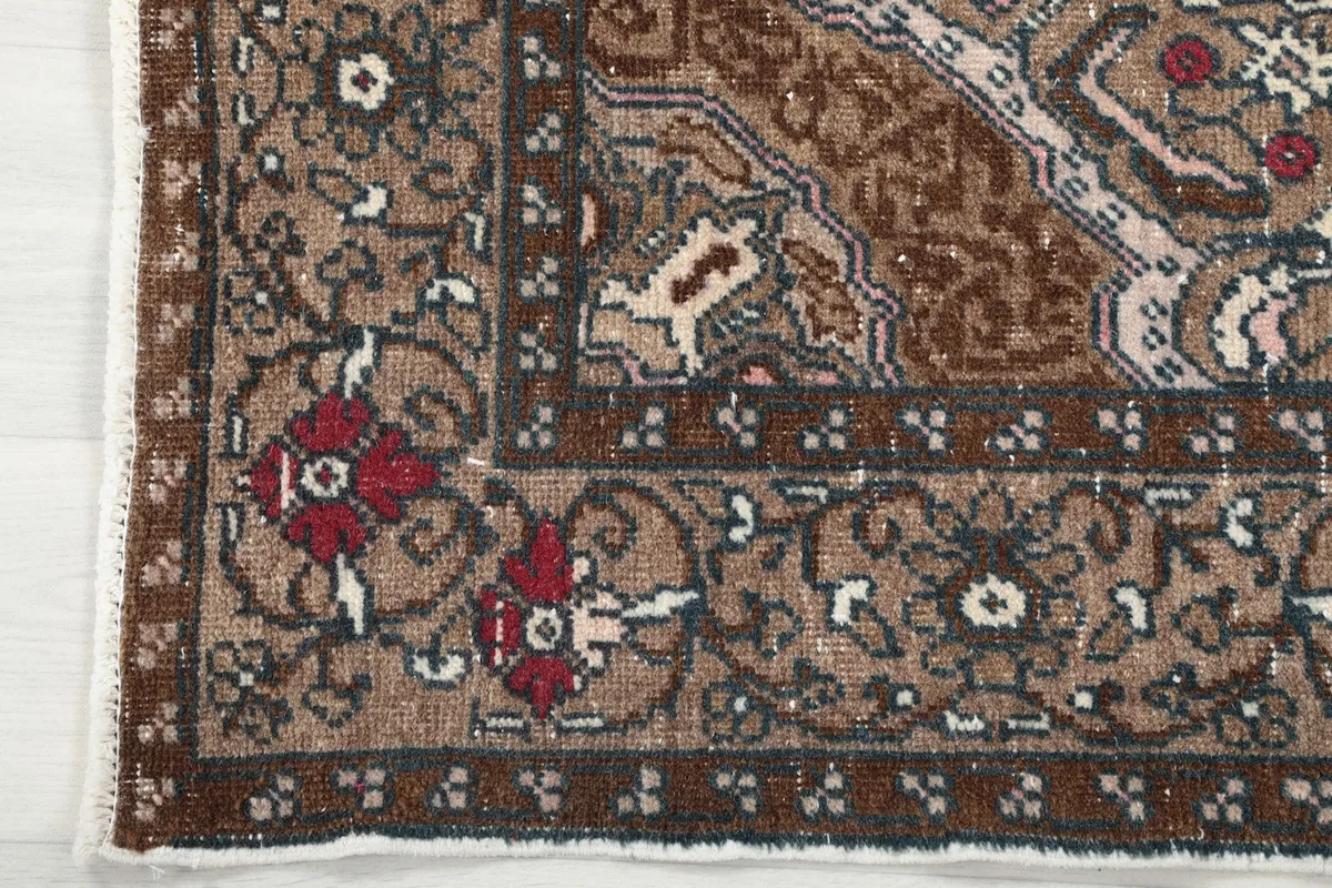 Close-up of the intricate brown border design with floral and geometric motifs