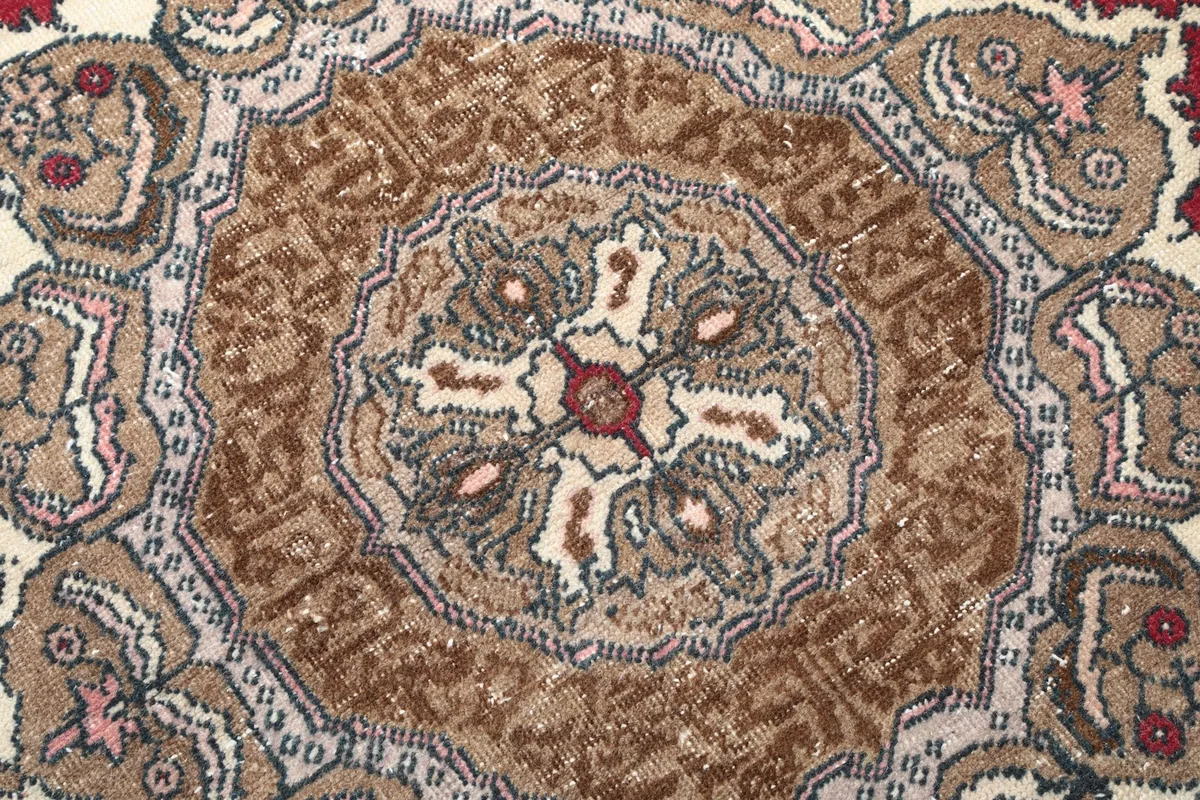 Extreme close-up of the hand-knotted wool pile, showing texture and color variations within the medallion