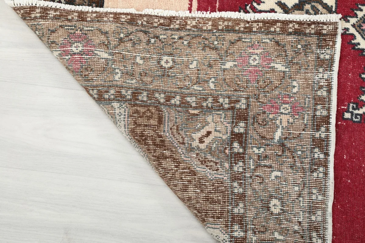 Underside of the rug's corner, showing the hand-knotted construction and cotton foundation