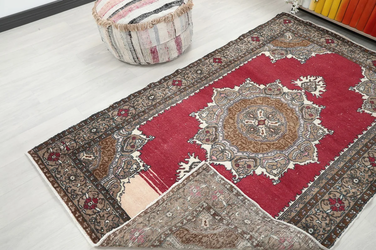 Rug with a corner folded over, revealing the cotton foundation and reverse side of the pile