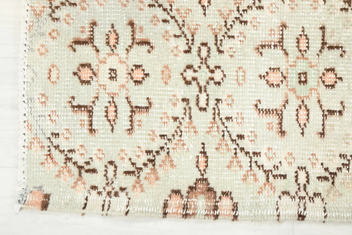 Detail of the rug's edge, showing the subtle color variations and the finished binding.