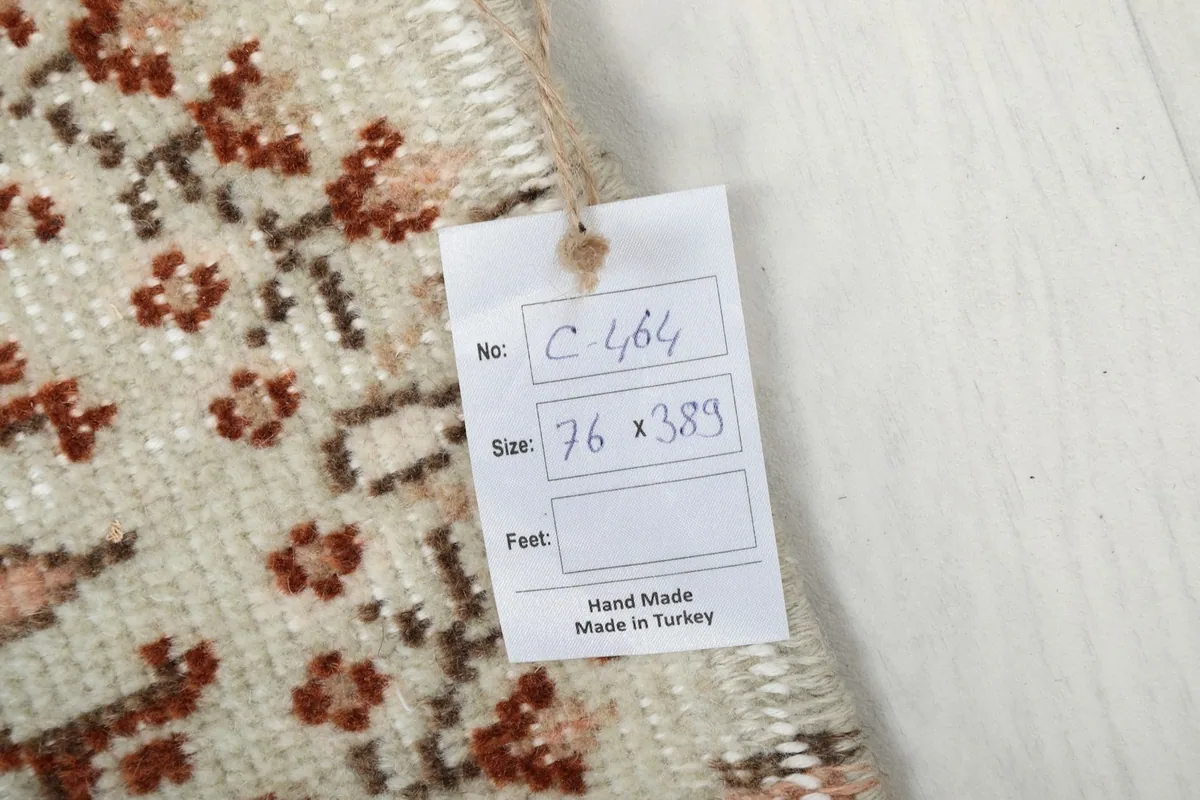 Close-up of the product tag attached to the rug, showing details like size (76 x 389 cm) and 'Hand Made in Turkey'.