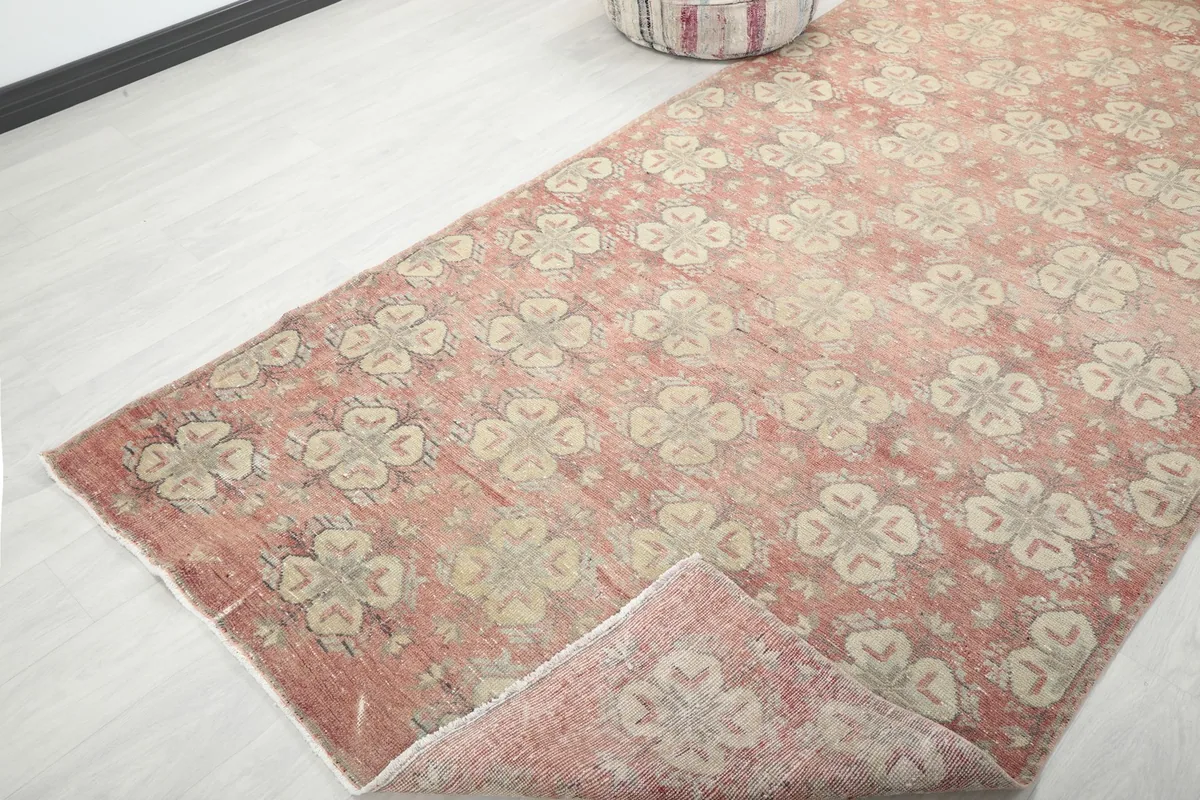 View of the rug with a corner folded back, showing the wool pile on cotton foundation and the reverse side.