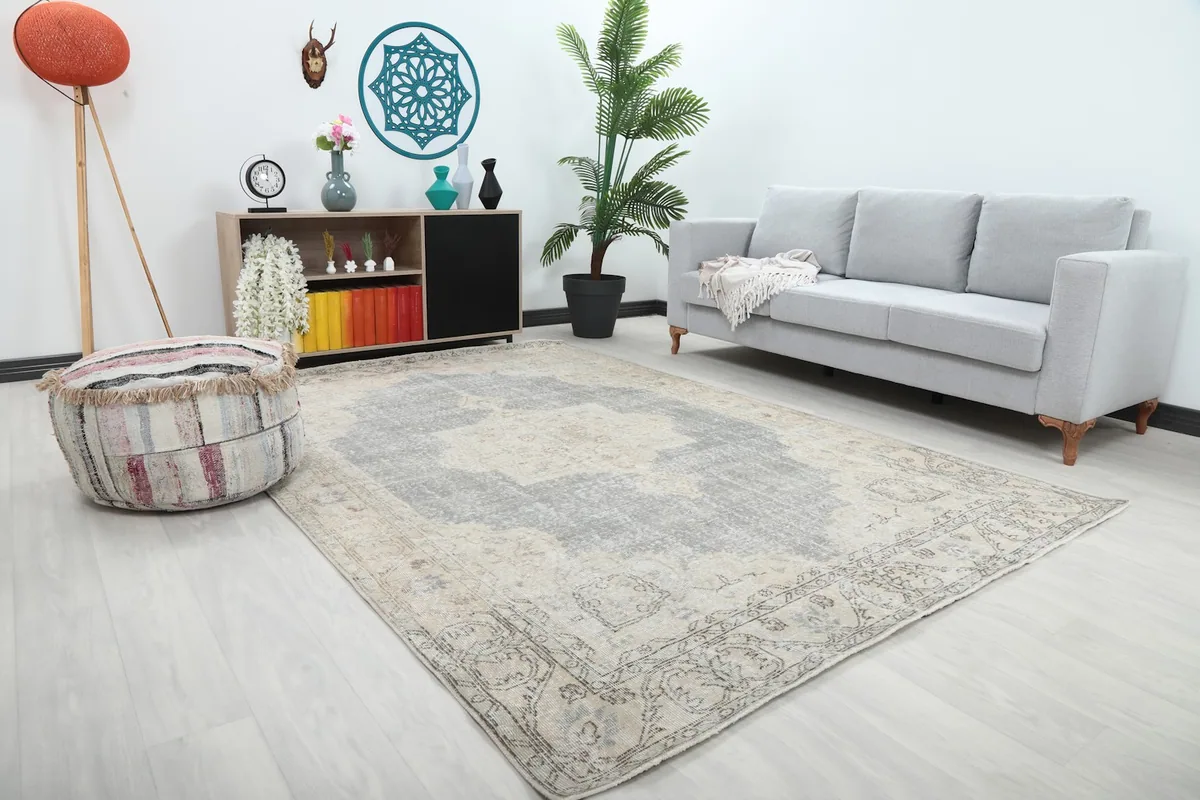 Angled view of the gray and ivory vintage rug in a modern living space with a grey sofa.