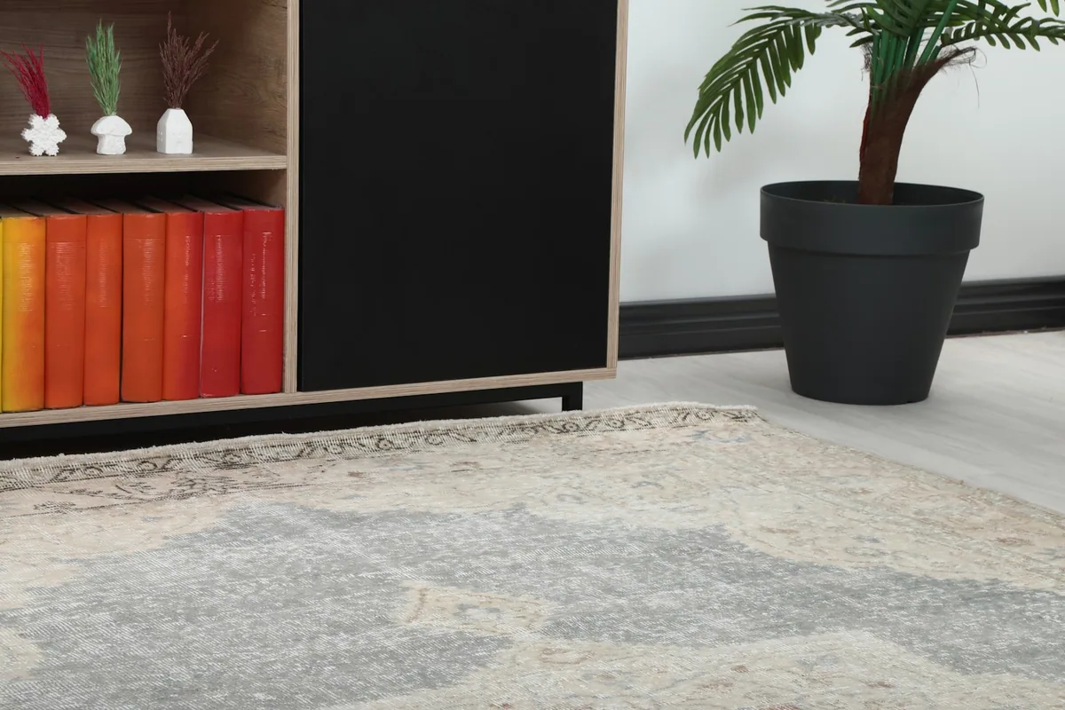 Close-up view of the rug's border and field, showing the low pile texture and subtle color variations.